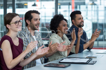 Business executives clapping in meeting at office