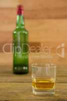Whiskey bottle and glass kept on table