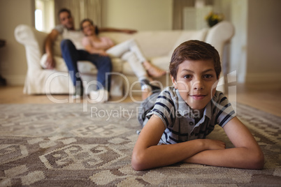 Portrait of boy lying in living room