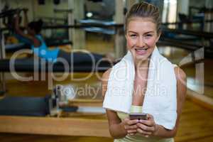 Portrait of beautiful fit woman using mobile phone after workout