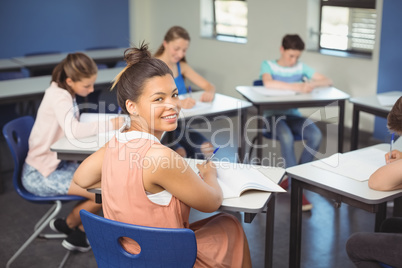 Schoolgirl sitting at desk in classroom