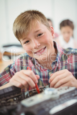 Schoolboy repairing a printer in the classroom