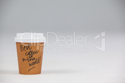 Disposable coffee cup with written text on white background