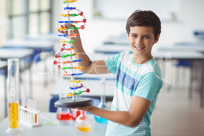 Portrait of schoolboy experimenting molecule model in laboratory Portrait of schoolboy experimenting molecule model in laboratory