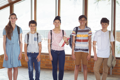 Portrait of happy students standing in corridor