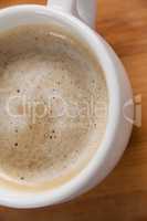 Close-up of white coffee cup with creamy froth