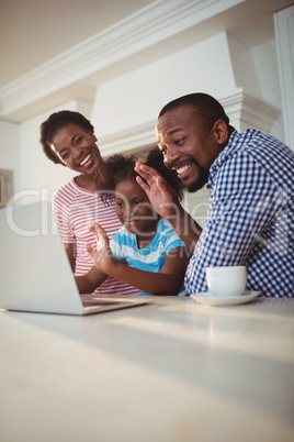 Happy family having a video call on laptop