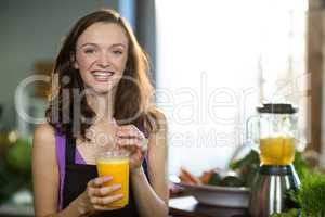 Shop assistant having fresh fruit juice at health grocery shop