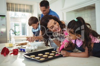 Happy family preparing cookies in kitchen