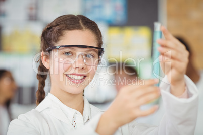 Portrait of schoolgirl doing a chemical experiment in laboratory