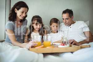 Parents and kids having breakfast in bed