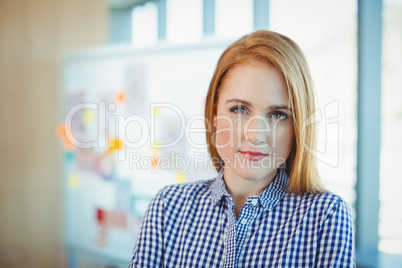 Portrait of female executive standing in conference room