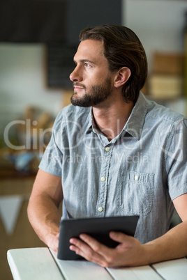 Male staff using digital tablet in grocery shop