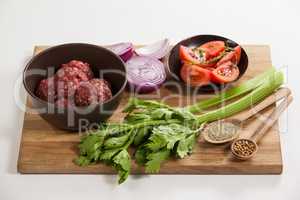 Minced beef and ingredients on wooden board