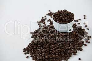 Cup of coffee filled with roasted coffee beans