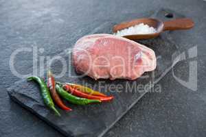 Sirloin chop, salt and chillies on slate plate