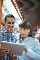 Executives using digital tablet travelling in train