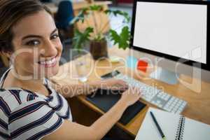 Smiling female graphic designer working on computer