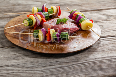 Sirloin chop and skewered vegetables on wooden board