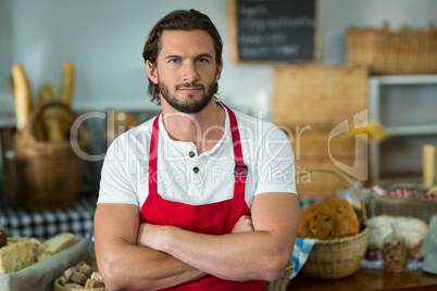 Portrait of bakery staff standing with arms crossed at counter