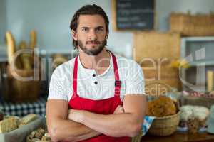 Portrait of bakery staff standing with arms crossed at counter