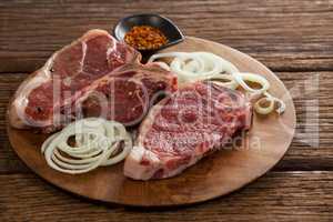 Blade chop, onions and spices on wooden round tray