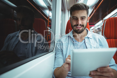Executive using digital tablet travelling in train