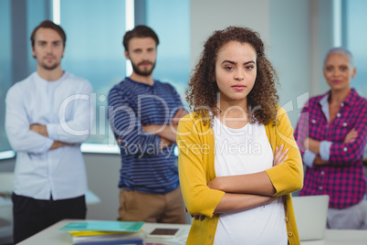 Portrait of executive standing with her colleagues in background