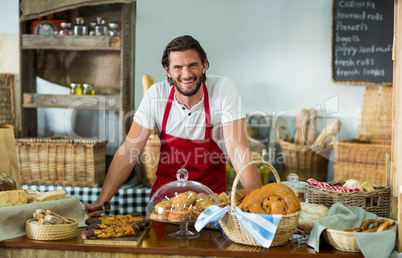 Portrait of male staff standing at counter in bake shop