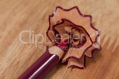 Close-up of maroon colored pencil with shavings