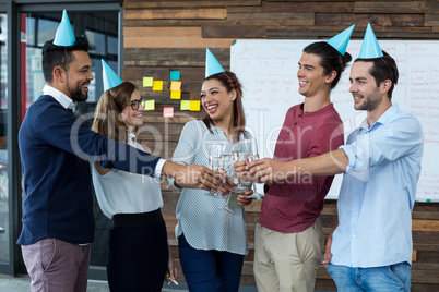 Businesspeople toasting glasses of champagne in office