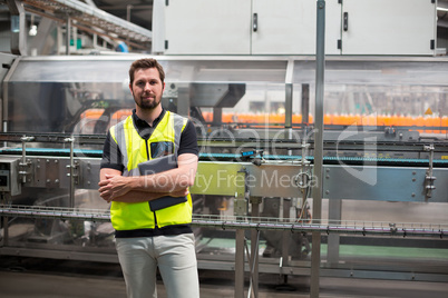 Portrait of confident factory worker standing with a digital tablet