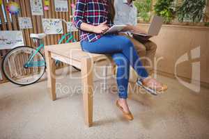 Graphic designers sitting on desk using laptop and digital tablet