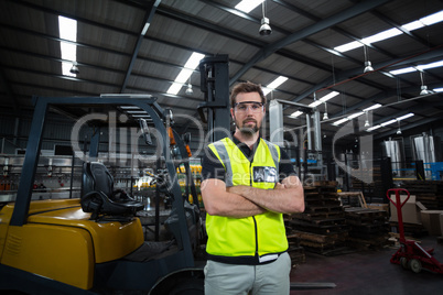 Portrait of factory worker standing with arms crossed