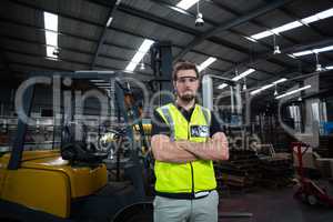 Portrait of factory worker standing with arms crossed