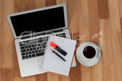 Cup of coffee with laptop, organizer, maker and pen