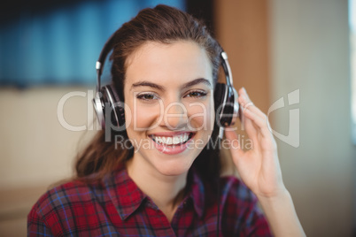 Female graphic designer listening music on headphones