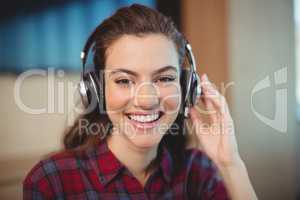 Female graphic designer listening music on headphones