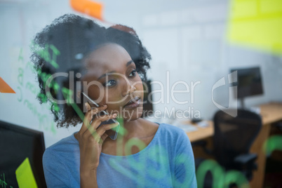 Female graphic designer talking on mobile phone