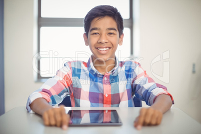 Schoolboy with digital tablet at desk Schoolboy with digital tablet at desk