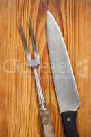 Knife and fork against wooden background