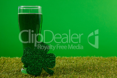 Glass of green beer and shamrock for St Patricks Day on grass