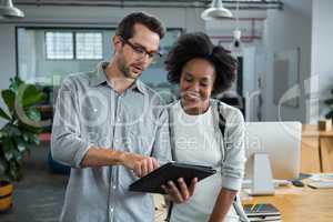 Man and woman discussing over digital laptop