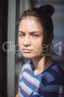 Worried schoolgirl standing in classroom