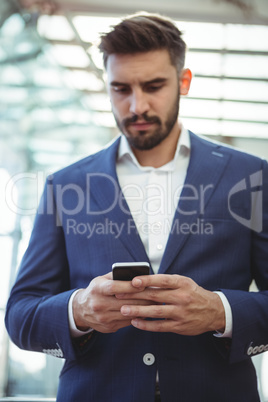 Attentive businessman using mobile phone