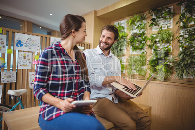 Graphic designers interacting while using laptop and digital tablet