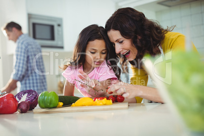 Mother and daughter preparing salad in kitchen