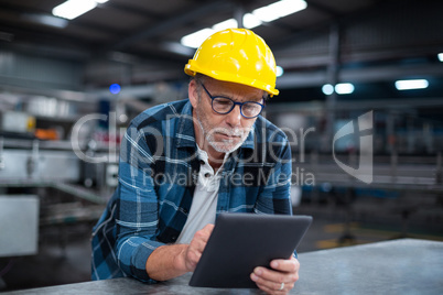 Factory worker using a digital tablet in factory