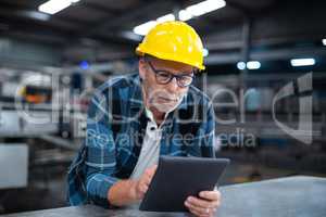 Factory worker using a digital tablet in factory