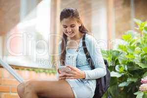 Happy schoolgirl using mobile phone